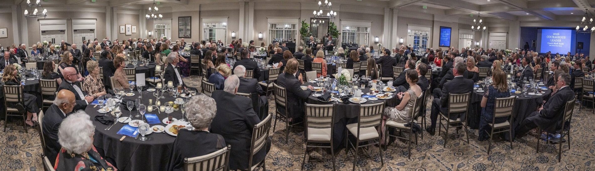 Panoramic photograph of ballroom and attendees.