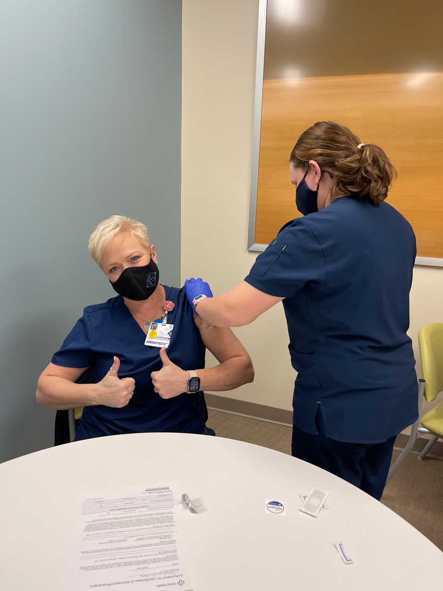 nurse receiving covid vaccine