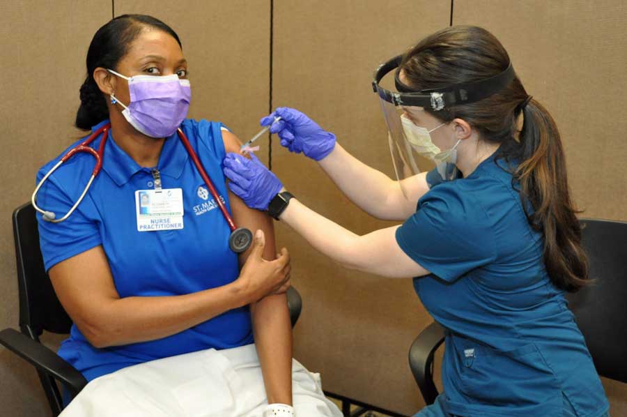 nurse receiving covid vaccine